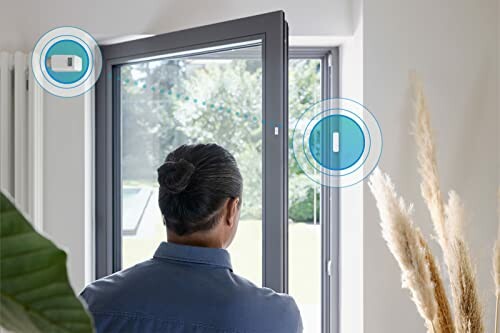 Mann bei offenem Fenster mit Smart-Sensoren
