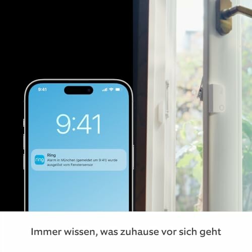 Smartphone zeigt Benachrichtigung von Ringsensor neben offenem Fenster.